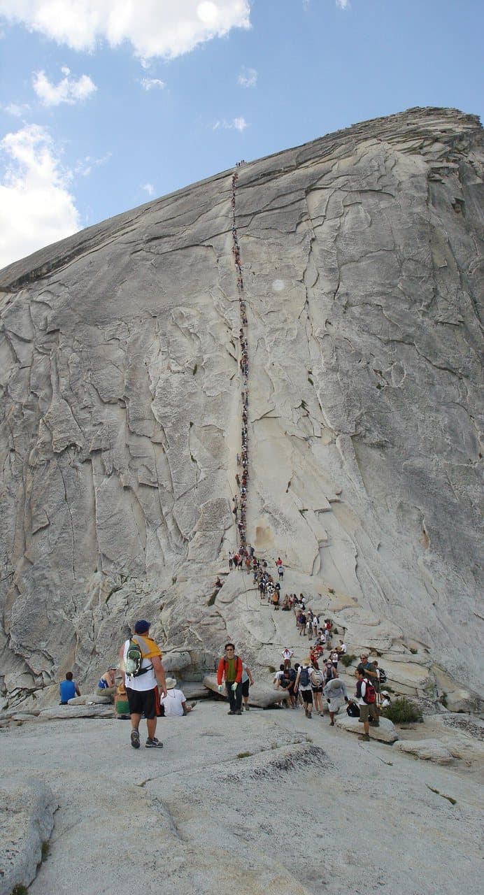 Hikers climbing the Half Dome cables up the granite dome