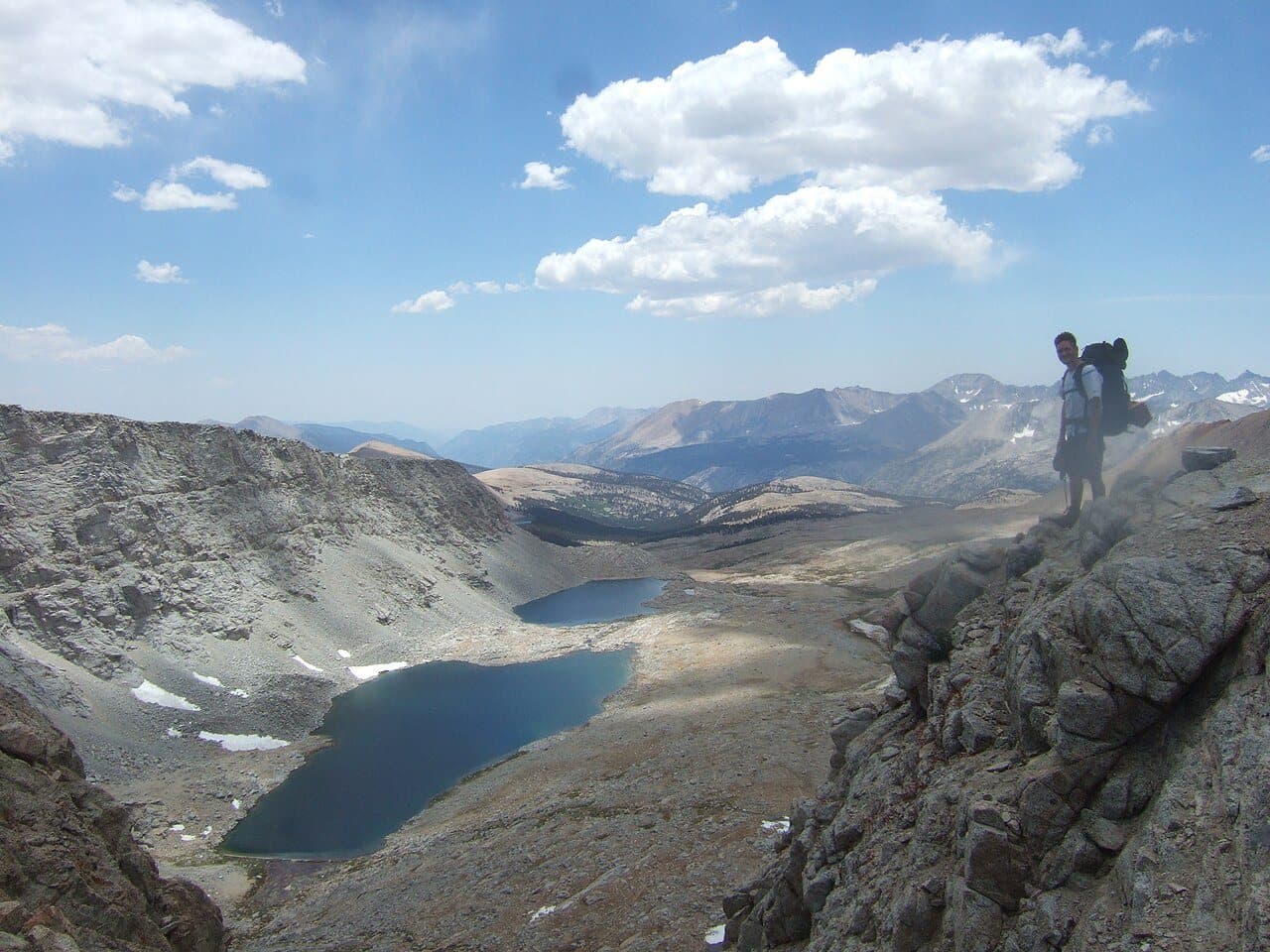 A hiker at Forester Pass looking down on lakes to the north