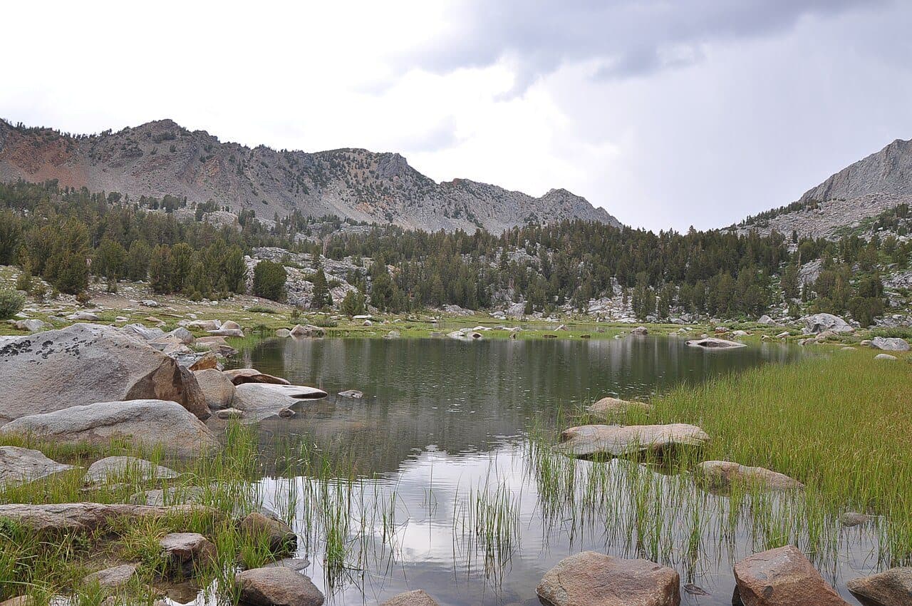 Rocky shore of Lake Virginia with peaks of the John Muir Wilderness