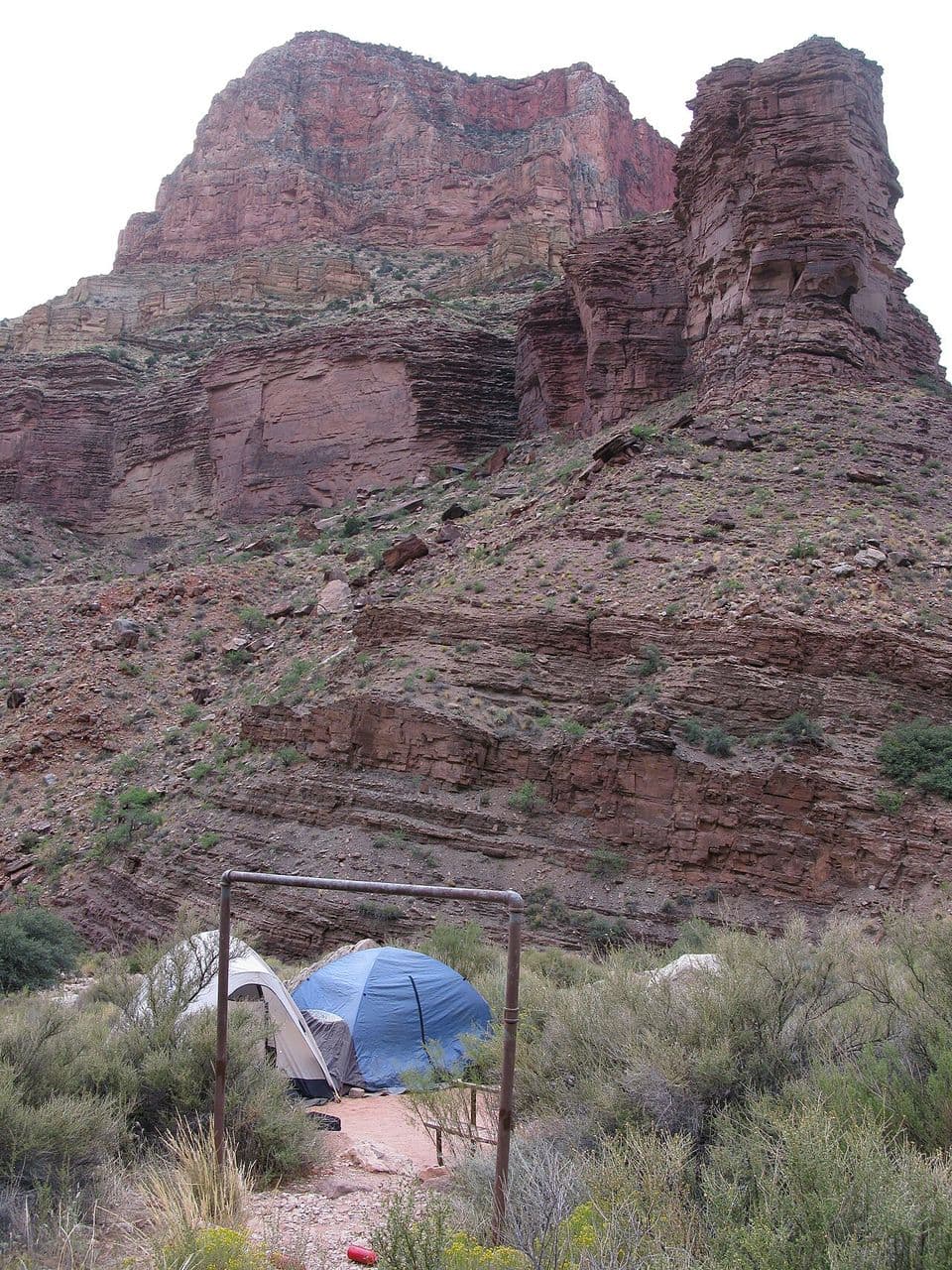 A tent at Cottonwood Campground below red canyon walls